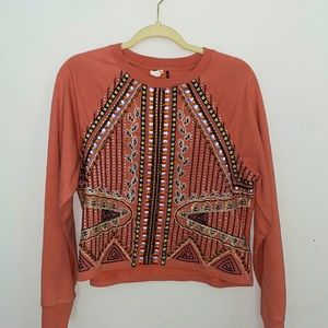 long sleeve sweater like shirt with different patterns in the front.